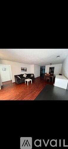 A living room with a couch, chair, and a painting on the wall.