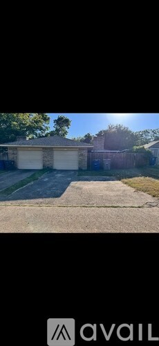 A two-car garage with a white door is situated in a driveway.