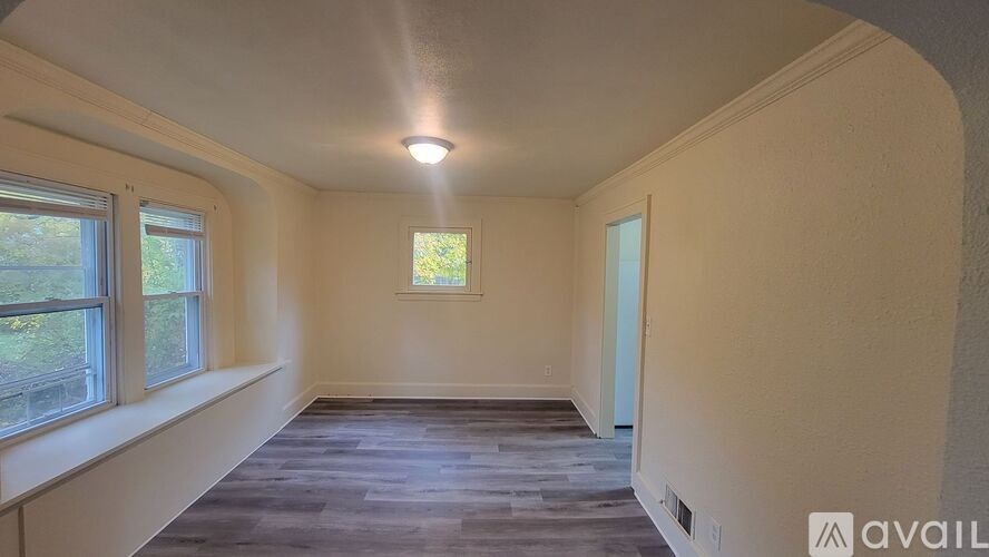 A room with a window and a door is available for rent.