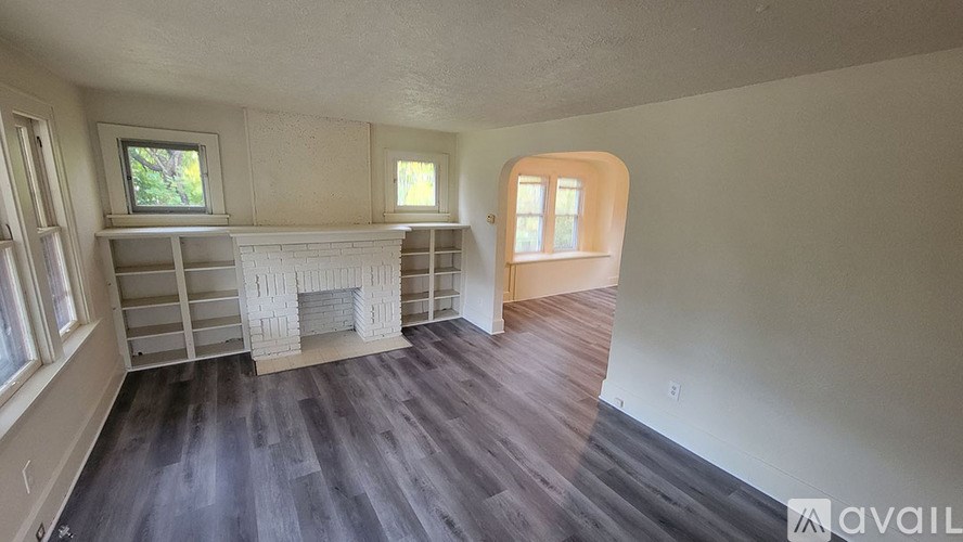 A room with a fireplace and wooden floors.