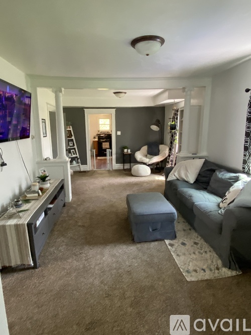 A living room with a grey couch and a white sideboard.