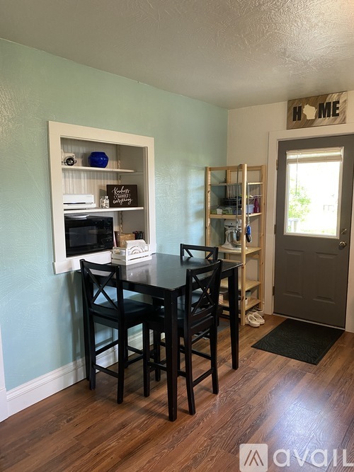 A dining room with a table and chairs.