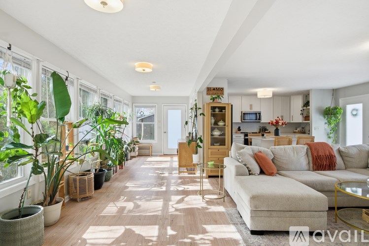 A living room with a white couch and a glass coffee table.