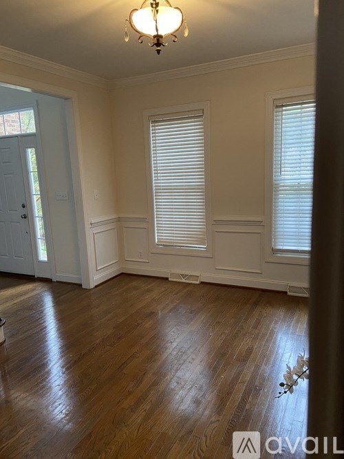 A room with wooden floors and a chandelier.
