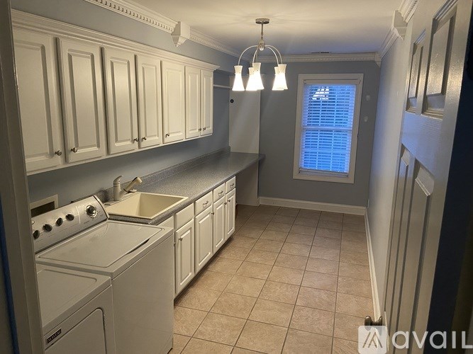 A kitchen with white cabinets and a stove top oven.