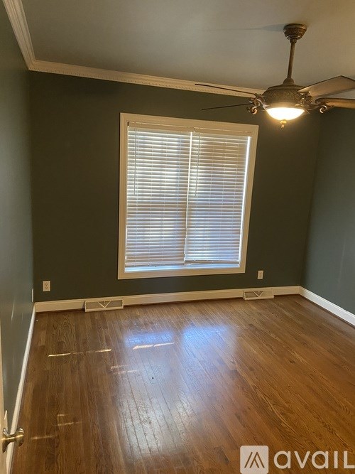 A room with wooden floors and a window with blinds.