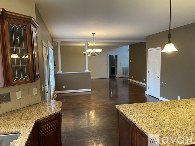 A kitchen with brown cabinets and a granite countertop.