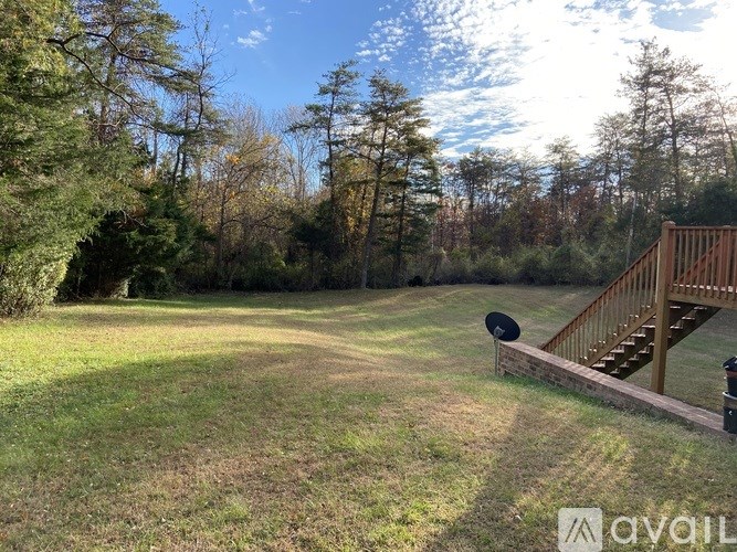 A backyard with a wooden deck and a grassy area.
