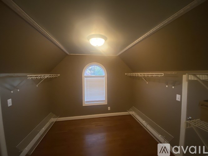 A room with a window and a wooden floor.