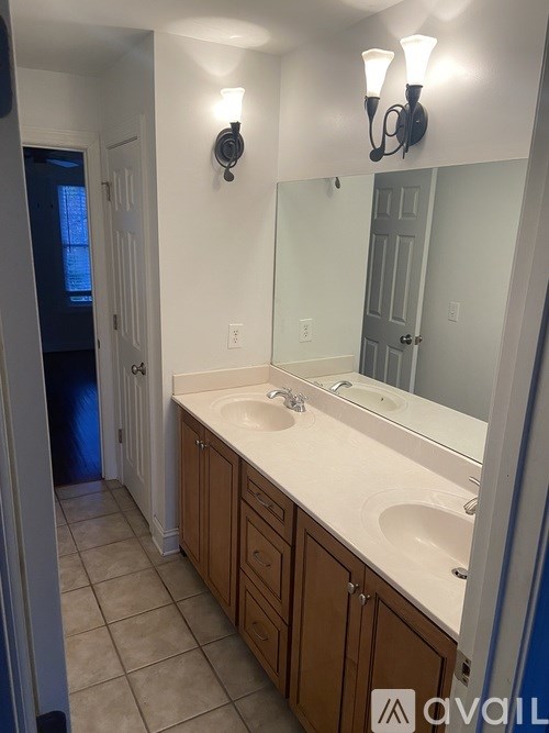 A bathroom with a sink, mirror and light fixture.
