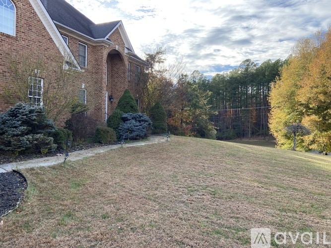 A spacious room with wooden floors and a ceiling fan.