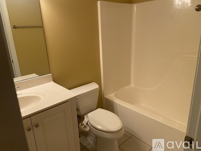 A bathroom with a toilet, sink, and bathtub.