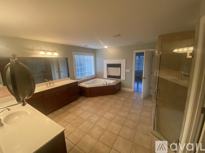 A spacious bathroom with a jacuzzi tub and double sink vanity.