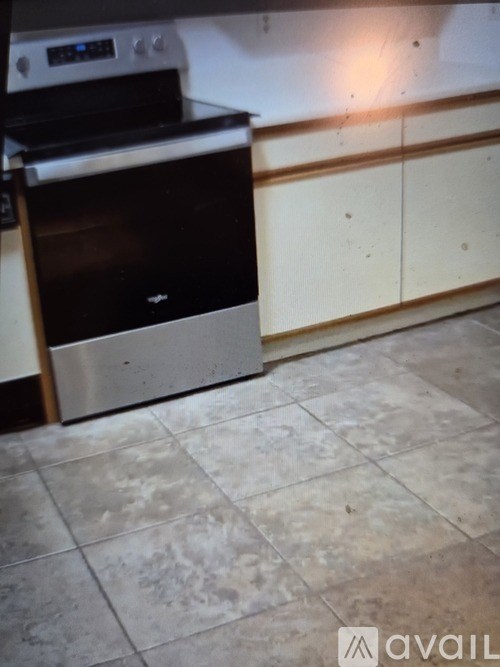 A kitchen with a stainless steel oven and tiled floor.