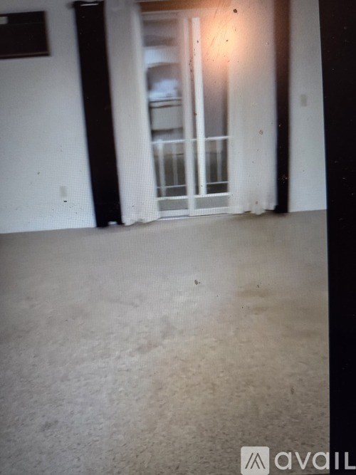 A room with a carpeted floor and a glass door.