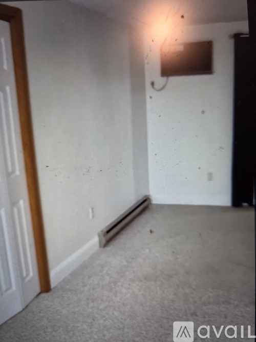 A room with a white wall and a brown object on it.