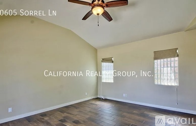 A room with a ceiling fan and a window with blinds.