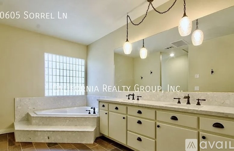 A bathroom with a tub, sink, and mirror.