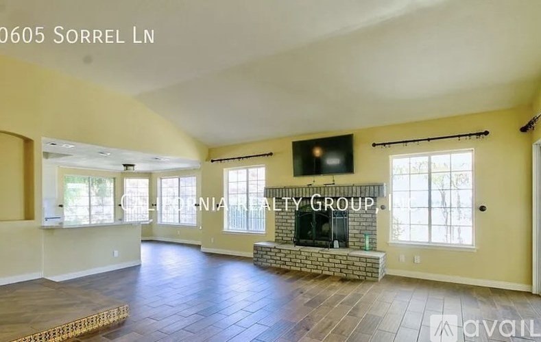 A spacious living room with a fireplace and a flat screen TV.