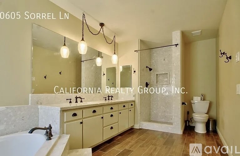 A bathroom with a tub, sink, toilet and a mirror.