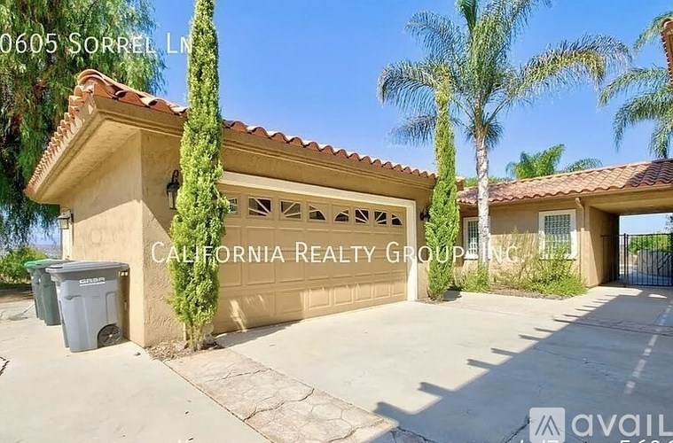 A house with a garage and palm trees in the background.