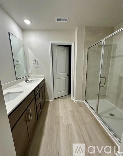 A bathroom with a sink, mirror, and shower.