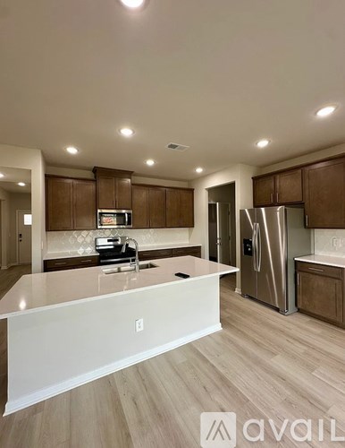 A kitchen with a white countertop and wooden cabinets.