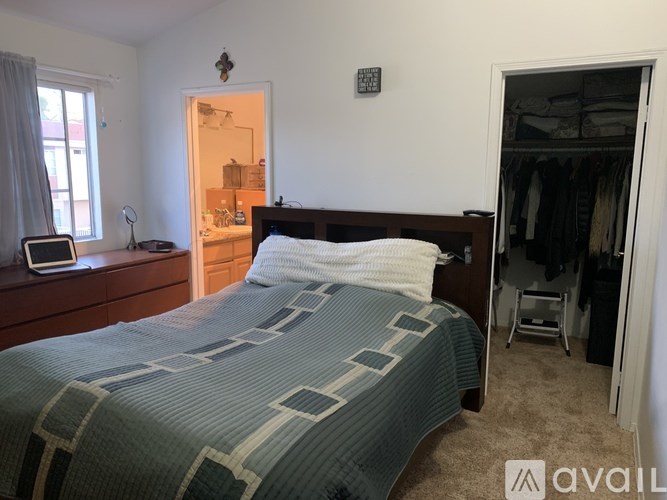 A bedroom with a bed, nightstand, and closet.