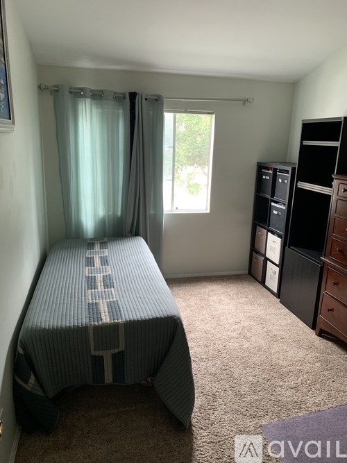 A bedroom with a bed, dresser, and window.