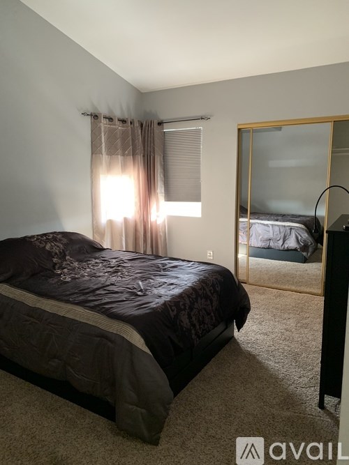 A bedroom with a bed and a window with curtains.