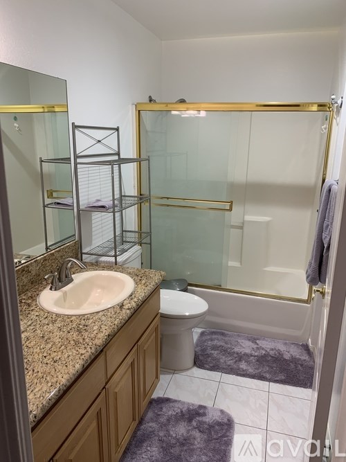 A bathroom with a sink, toilet, and shower.