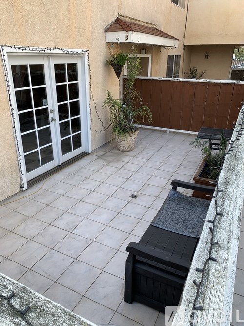 A patio with a table and chairs and a potted plant.
