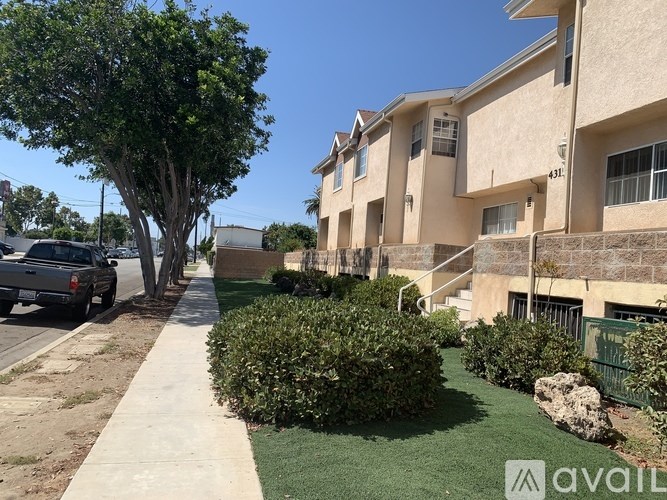 A residential area with apartment buildings and a sidewalk.