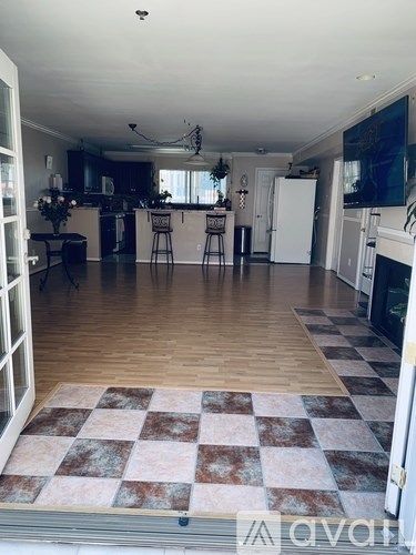 A large open plan living and kitchen area with a checkered floor.