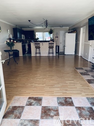 A kitchen with a white refrigerator and wooden floors.