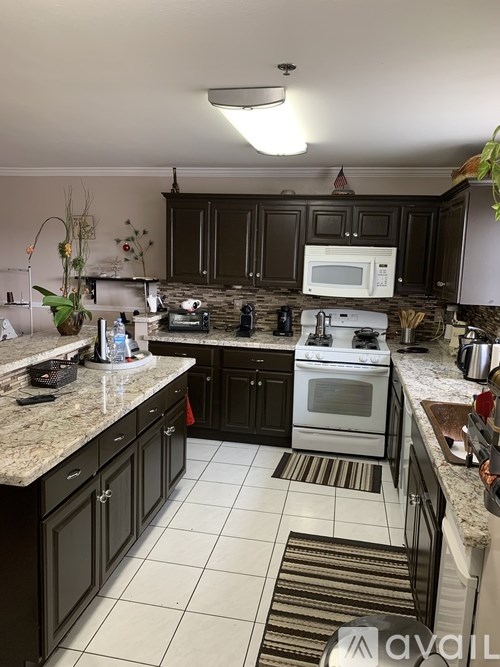 A kitchen with a white oven and black cabinets.