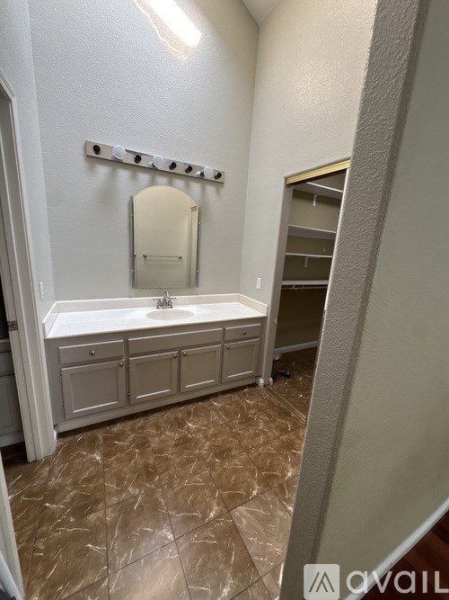A bathroom with a brown floor and white walls.