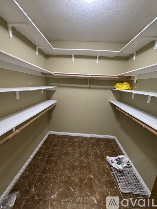 A walk-in closet with shelves and a tiled floor.