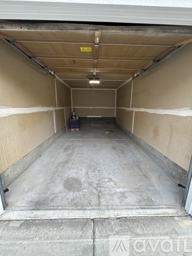 The image shows an empty garage with concrete flooring and walls.