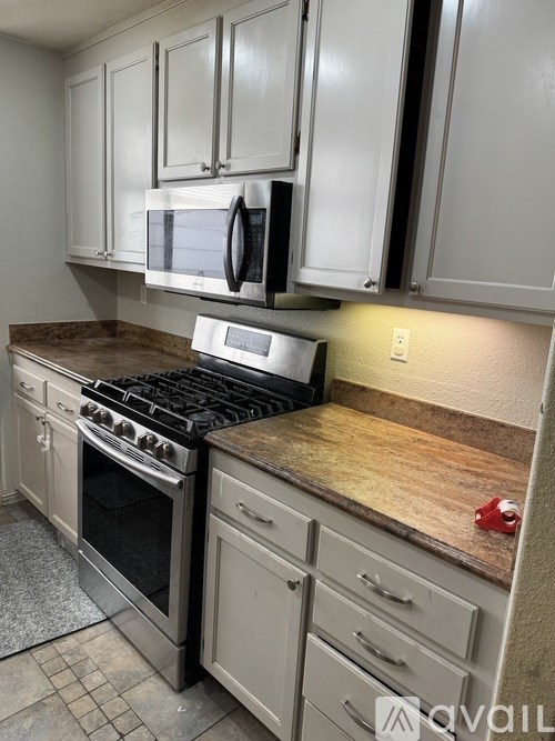A kitchen with a stove top oven and microwave above it.
