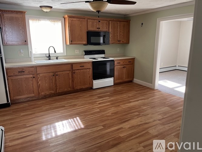A kitchen with wooden cabinets and a black stove top oven.