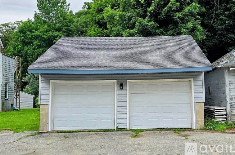 A two-car garage with a grey roof and white doors is available for rent.