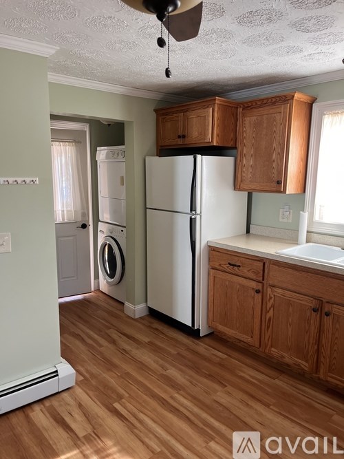 A kitchen with a white refrigerator and a washing machine.