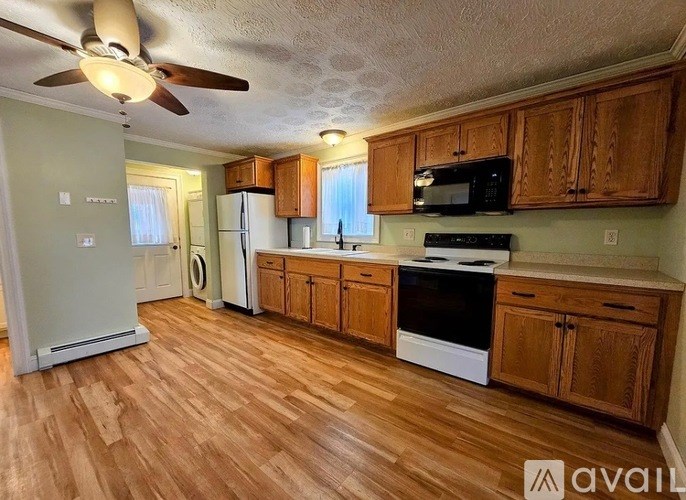 A kitchen with wooden cabinets and a black stove top oven.