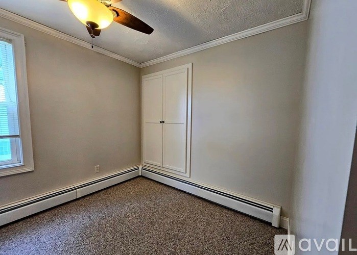 A room with a ceiling fan and a window.