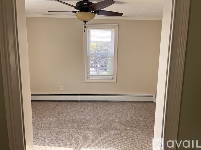 A room with a ceiling fan and a window.