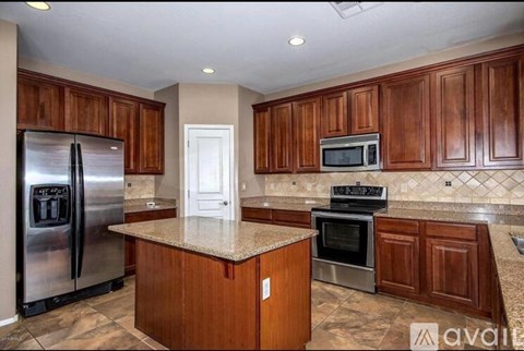 A kitchen with wooden cabinets and a granite countertop.
