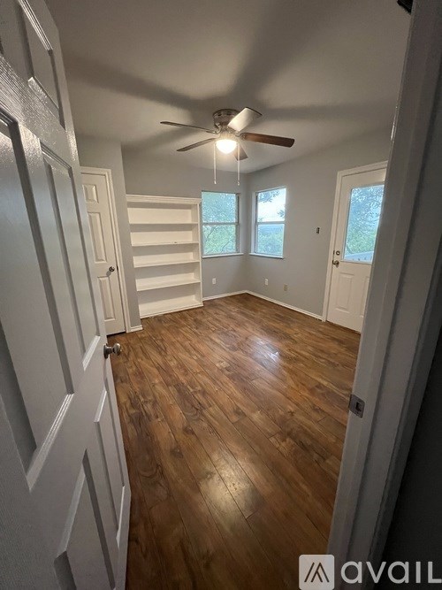 A room with wooden floors and a ceiling fan.