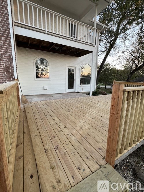 A wooden deck with a white house in the background.