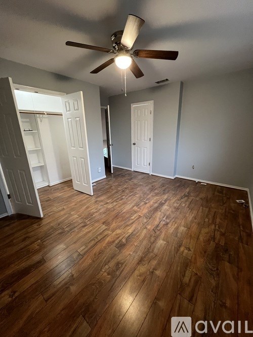 A room with wooden flooring and a ceiling fan.